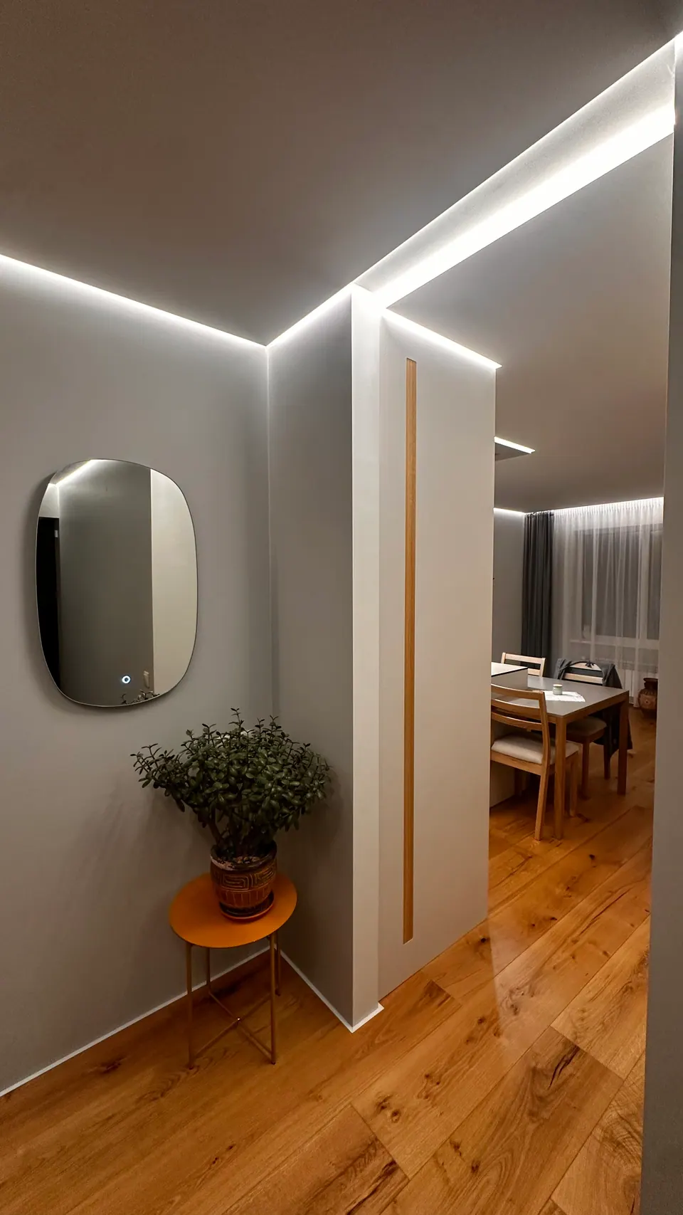 Entrance hall with LED-lit shadow gaps along the junctions between the walls and the ceiling